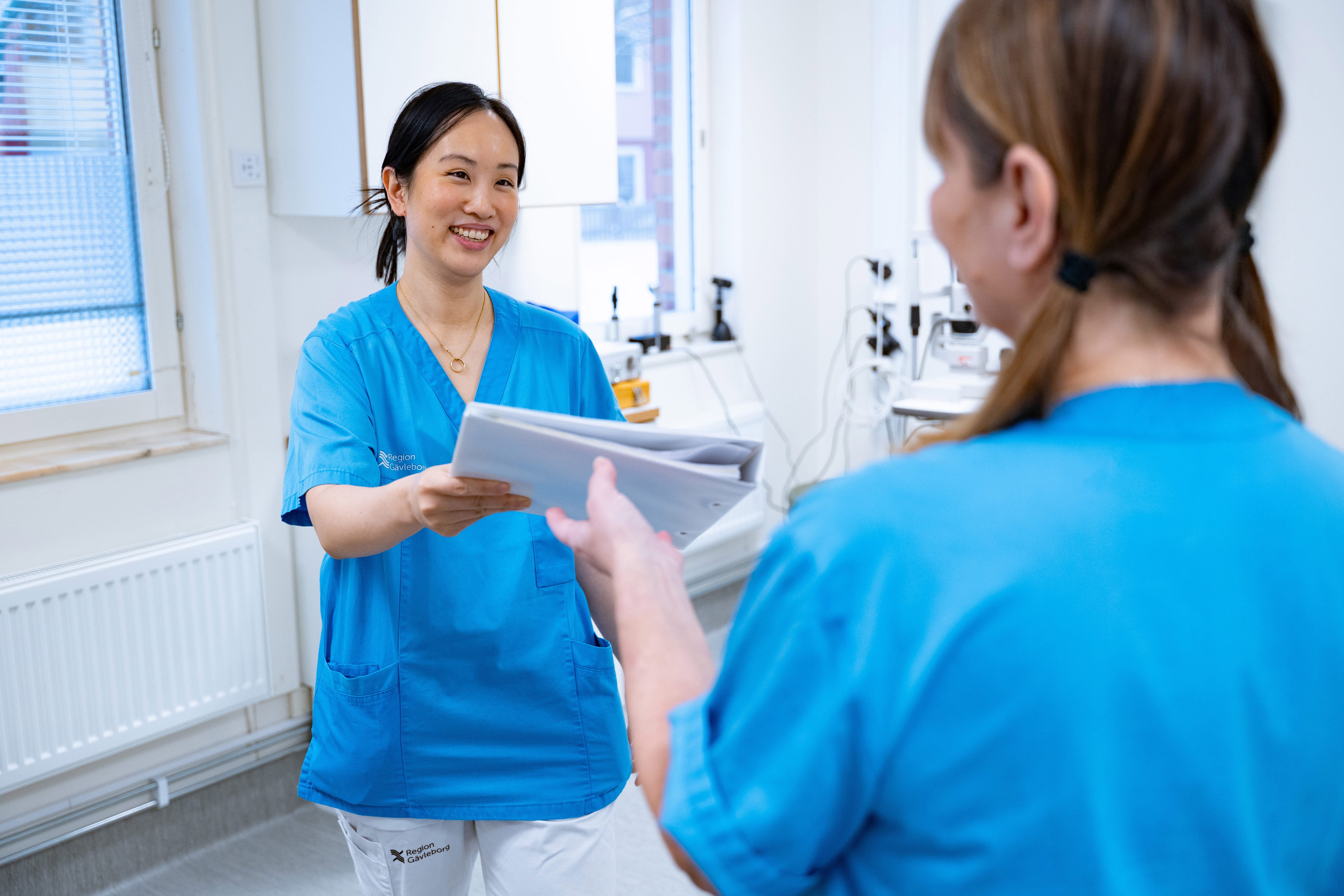 Vårdpersonal lämnar dokument till kollega